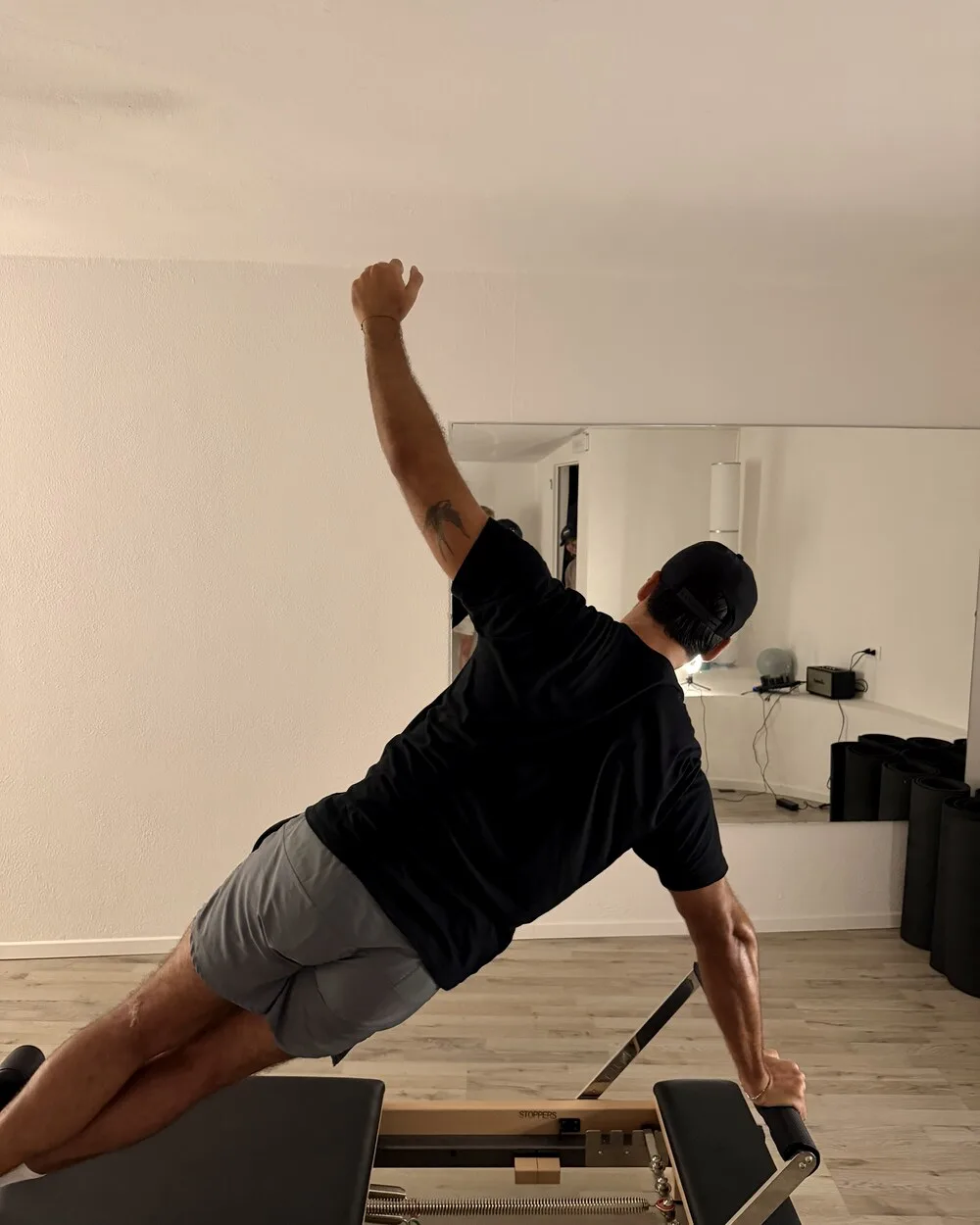Client in a side plank reach on the reformer