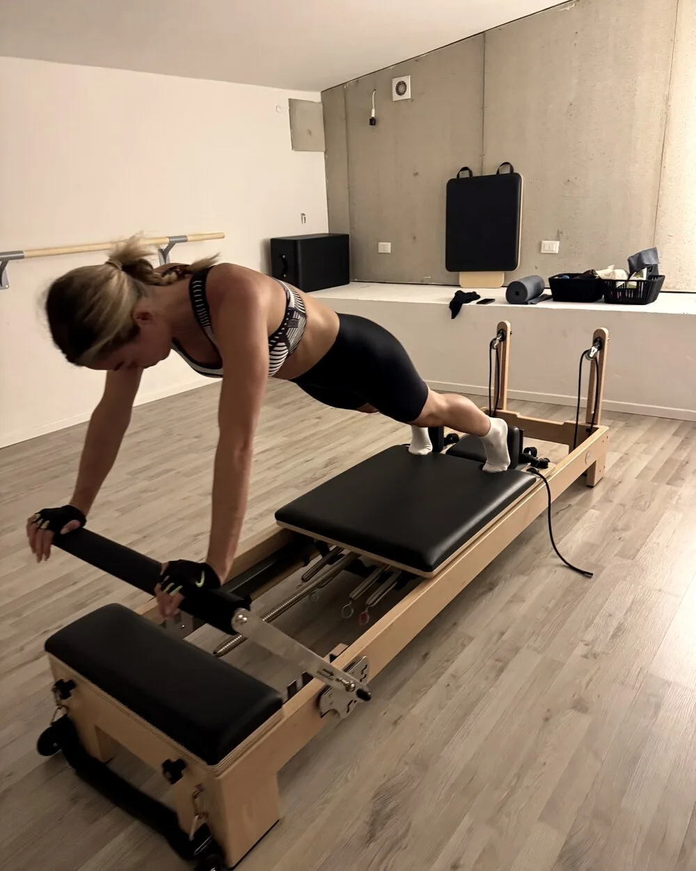 Client holding a plank on the reformer